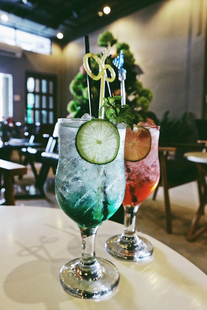 Servicios Refreshing cocktails with lime garnish served in a cozy indoor bar setting.